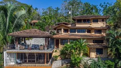 an exterior view of a house with palm trees at Casa Sonora - Ocean View in Carrillo