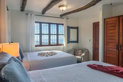 a bedroom with two beds and a window at Casa Sonora - Ocean View in Carrillo