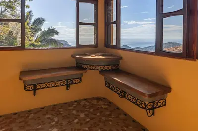 a room with two benches in front of two windows at Casa Sonora - Ocean View in Carrillo
