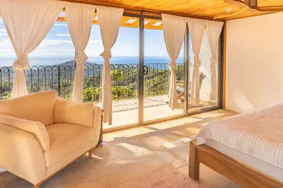 a bedroom with a bed and a view of the ocean at Casa Sonora - Ocean View in Carrillo