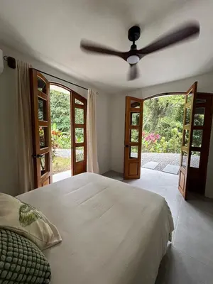 a bedroom with a bed with a ceiling fan at Casa Selvática Wildlife-Happiness in Uvita