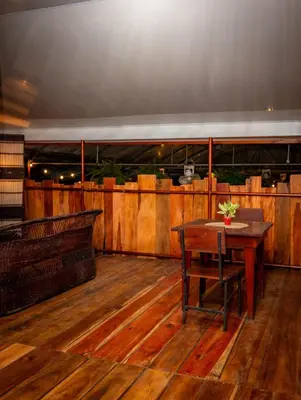 a room with a wooden floor and a table at Hotel La Pérgola in Sarapiquí