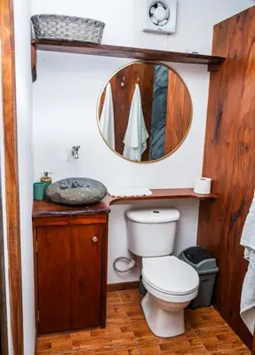 a bathroom with a toilet and a mirror at Hotel La Pérgola in Sarapiquí