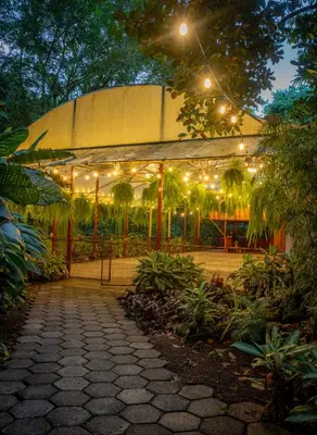a pavilion with lights in a garden at night at Hotel La Pérgola in Sarapiquí