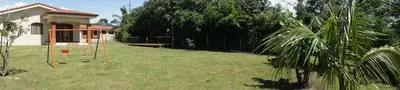 a yard with a swing set in the grass at Casa Andalucia Apartments in Santo Domingo