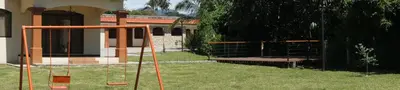 a swing set in the yard of a house at Casa Andalucia Apartments in Santo Domingo