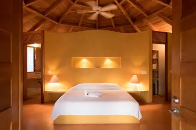 a bedroom with a white bed with two lamps at Hotel Playa Negra in Playa Negra