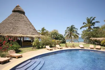 a pool at a resort with chairs and a gazebo at Hotel Playa Negra in Playa Negra