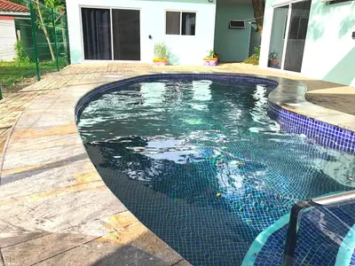 a swimming pool in a yard with a house at Screened-In Porch! Short Walk To Beach! in Sámara