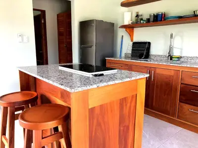 a kitchen with a island with a stove top at Screened-In Porch! Short Walk To Beach! in Sámara