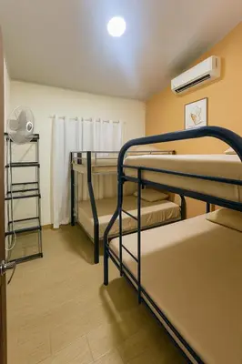 a room with three bunk beds and a fan at Casa Sol in Santa Rita