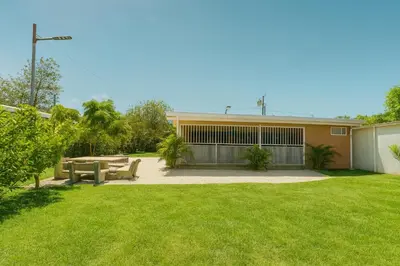 a house with a patio and a grass yard at Casa Sol in Santa Rita