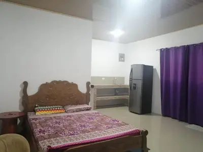 a bedroom with a bed and a refrigerator at CASA TICA Apart 1 y 2 in Potrero