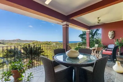 a patio with a table and chairs and the ocean at Luxury Condo at Reserva Conchal with Incredible Ocean Views and Exclusive Beach Club Access in Brasilito