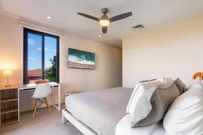 a bedroom with a bed and a ceiling fan at Luxury Condo at Reserva Conchal with Incredible Ocean Views and Exclusive Beach Club Access in Brasilito