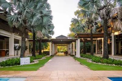a walkway with palm trees in front of a building at Luxury Condo at Reserva Conchal with Incredible Ocean Views and Exclusive Beach Club Access in Brasilito