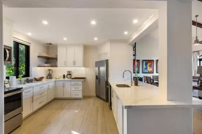 a kitchen with white cabinets and stainless steel appliances at Luxury Condo at Reserva Conchal with Incredible Ocean Views and Exclusive Beach Club Access in Brasilito