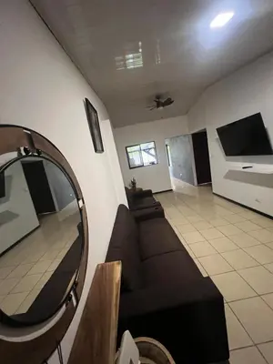 a living room with a couch and a mirror at Casa Lapas in Guayabal