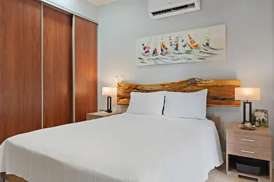 a bedroom with a large white bed and wooden cabinets at Tropical Balcony 10-minute walk to Adventures in Santa Cruz