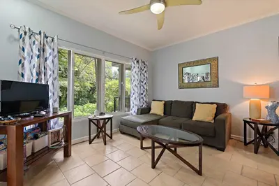 a living room with a couch and a tv at Tropical Balcony 10-minute walk to Adventures in Santa Cruz