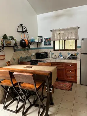 a kitchen with a wooden table and a refrigerator at Casa Zen in Potrero
