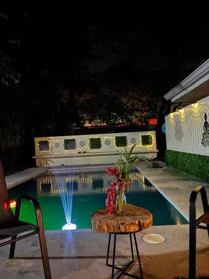 a pool at night with a table with flowers on it at Casa Zen in Potrero