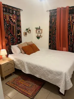 a bedroom with two beds with curtains and a rug at Casa Zen in Potrero