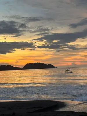 a boat in the water at sunset on the beach at Casa Zen in Potrero