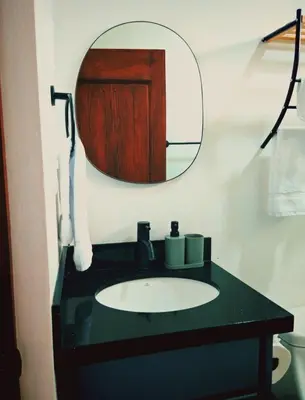 a bathroom with a sink and a mirror at Cabaña Tranquila en la Naturaleza in Tigra