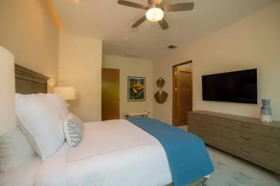 a bedroom with a bed and a flat screen tv at Casa Blue Sail 6 bdr Ocean View in Herradura