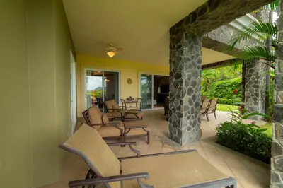 a patio with chairs and a stone pillar at Vista Bahia 1G - 3bed 3 bath Ocean View in Herradura