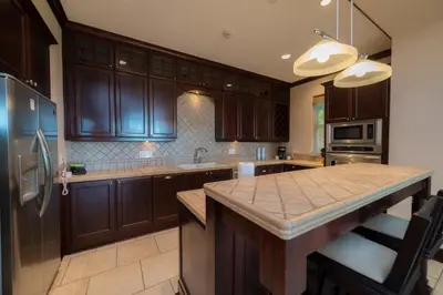 a kitchen with wooden cabinets and a large kitchen island at Vista Bahia 1G - 3bed 3 bath Ocean View in Herradura