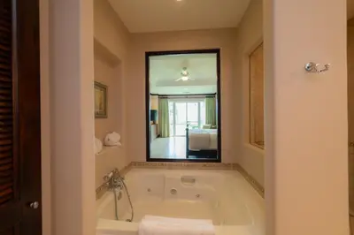 a bath tub in a bathroom with a large mirror at Vista Bahia 1G - 3bed 3 bath Ocean View in Herradura