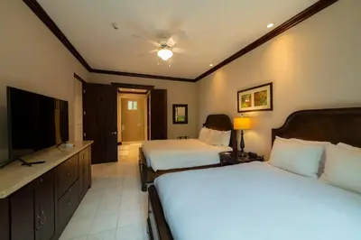 a bedroom with two beds and a flat screen tv at Vista Bahia 1G - 3bed 3 bath Ocean View in Herradura