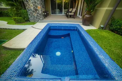 a blue swimming pool in the yard of a house at Vista Bahia 3D - 3bdr 3bath plunge pool in Herradura