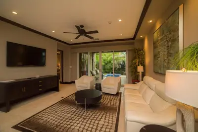 a living room with a white couch and a ceiling fan at Vista Bahia 3D - 3bdr 3bath plunge pool in Herradura