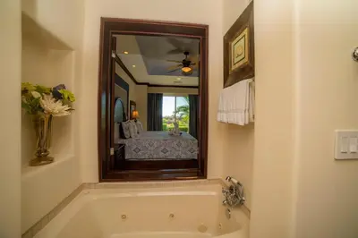 a bathroom with a tub and a large mirror at Vista Bahia 3F 1 bedr 1 1 and a half bath ocean view in Herradura