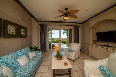 a living room with a couch and a ceiling fan at Vista Bahia 3F 1 bedr 1 1 and a half bath ocean view in Herradura