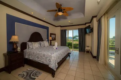 a bedroom with a bed and a ceiling fan at Vista Bahia 3F 1 bedr 1 1 and a half bath ocean view in Herradura