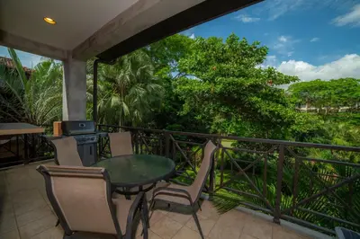a balcony with a table and chairs and trees at Veranda 2B - 3 bdr 3 bath in La Mona
