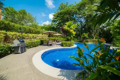 a swimming pool in a garden with trees at Veranda 2B - 3 bdr 3 bath in La Mona