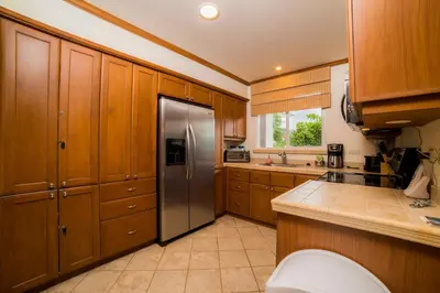 a kitchen with wooden cabinets and a stainless steel refrigerator at Veranda 2B - 3 bdr 3 bath in La Mona
