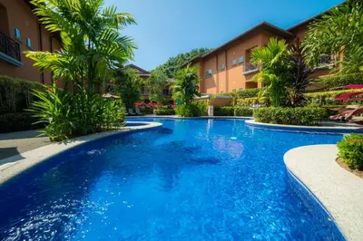 a swimming pool in a resort with palm trees at Veranda 4F - 2 bdr -2 bath in La Mona