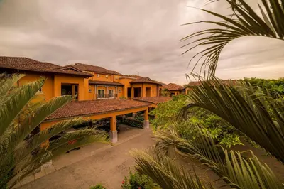 a row of yellow houses with palm trees at Veranda 5A - 1 bdr 1 bath in La Mona