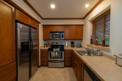 a kitchen with wooden cabinets and a stainless steel refrigerator at Veranda 5H - 1 Bedr 1 Bath in La Mona