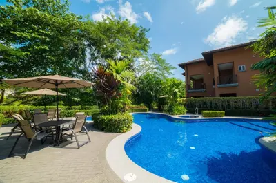 a swimming pool with a table and chairs next to a house at Veranda 8F - 2 bdr 2 bath - Condo in La Mona