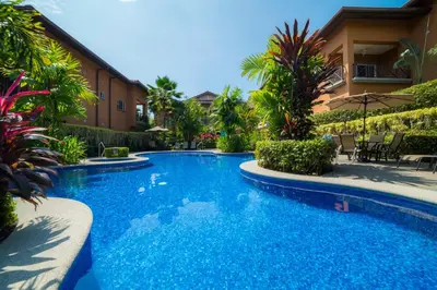 a swimming pool in front of a house at Veranda 8F - 2 bdr 2 bath - Condo in La Mona
