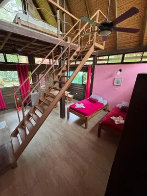 a room with a staircase and a pink wall at Cabuya Lodge in Cabuya