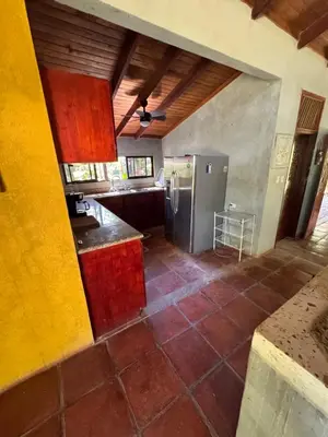 a kitchen with a stainless steel refrigerator in a room at Cabuya Lodge in Cabuya