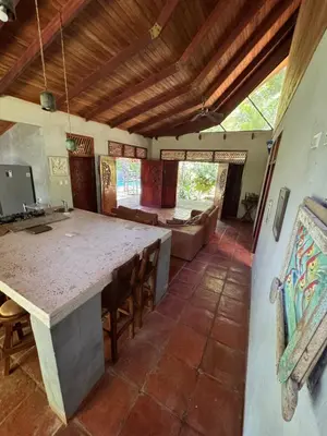 a kitchen with a large table and a living room at Cabuya Lodge in Cabuya